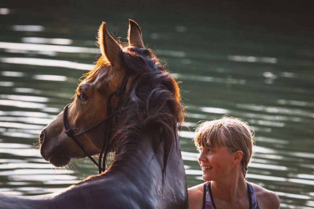 Women and her horse near water