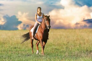 Girl Riding a horse through a field